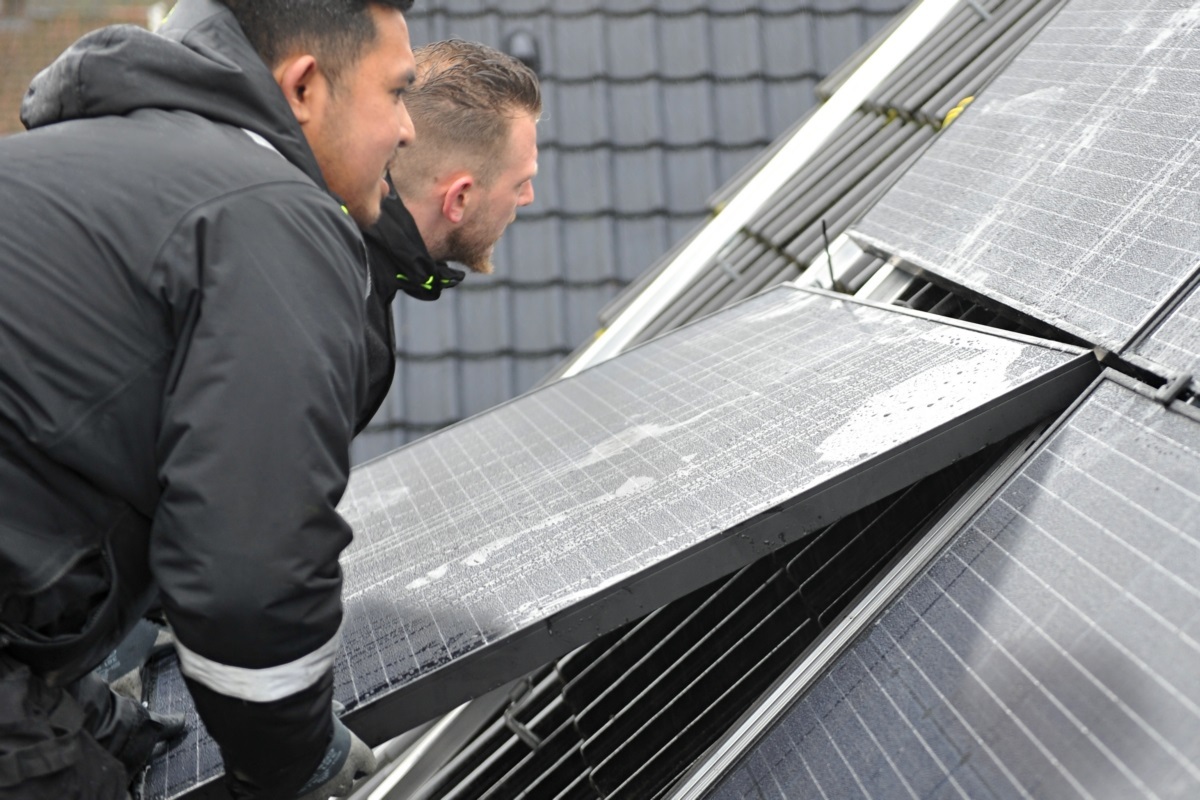 foto van twee mannen die zonnepanelen op een dak plaatsen